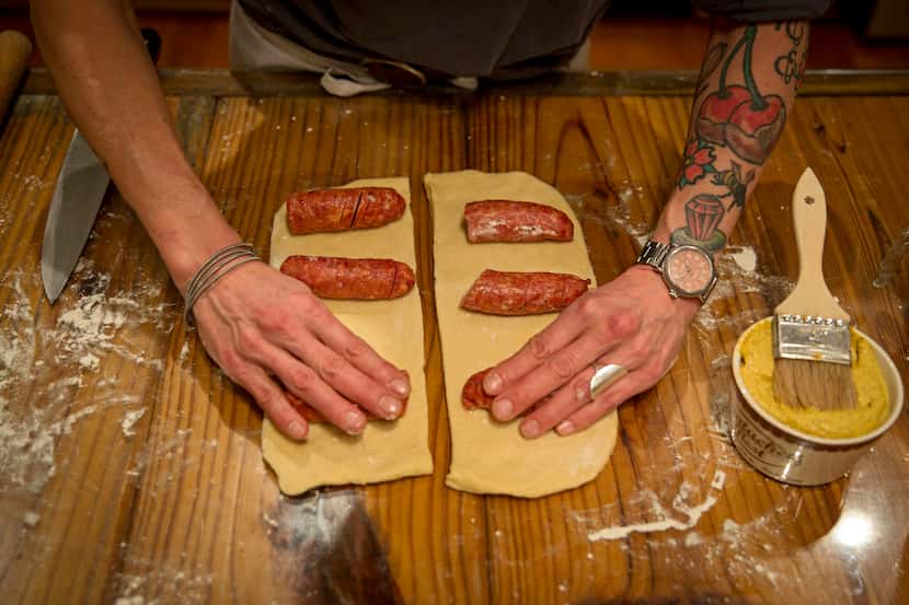 Katherine Clapner places sausages into cut pieces of dough as she makes kolaches at her home...