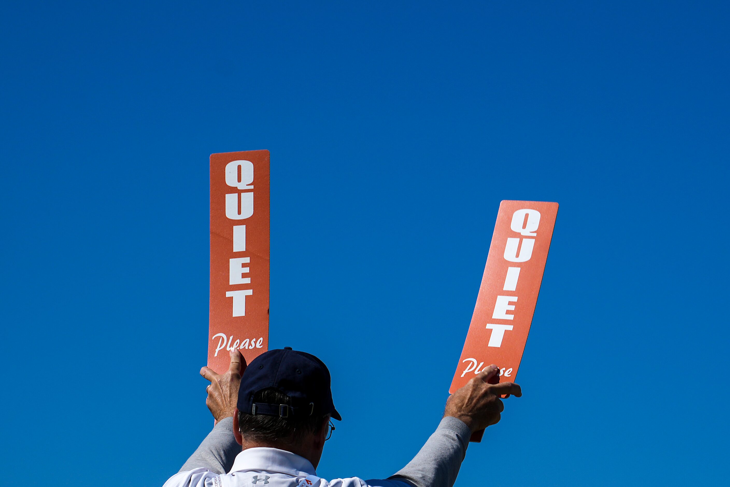 A marshal calls for quiet for a player’s tee shot on the 18th hole during the final round of...