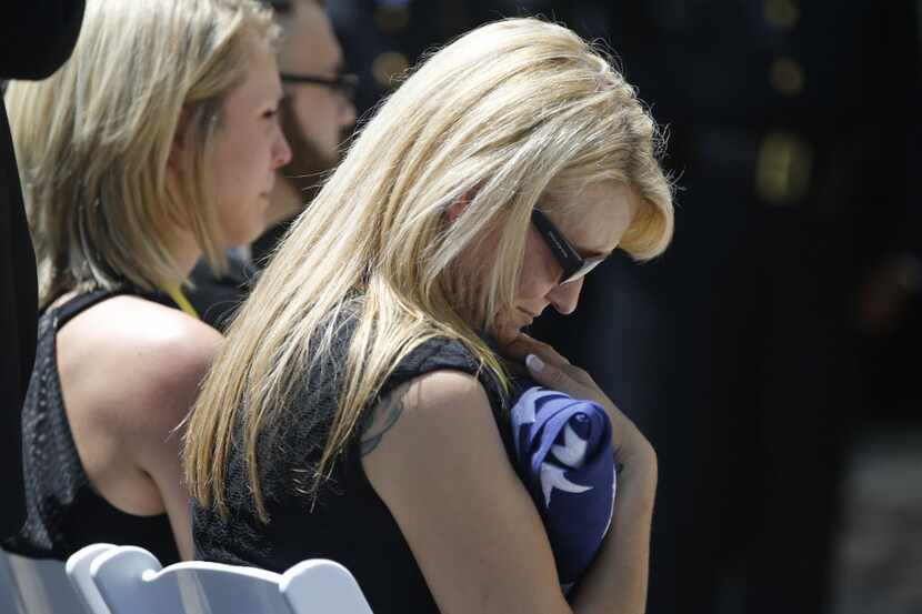 Tiffany McCullers holds an American flag during a memorial service for her husband, SMU...