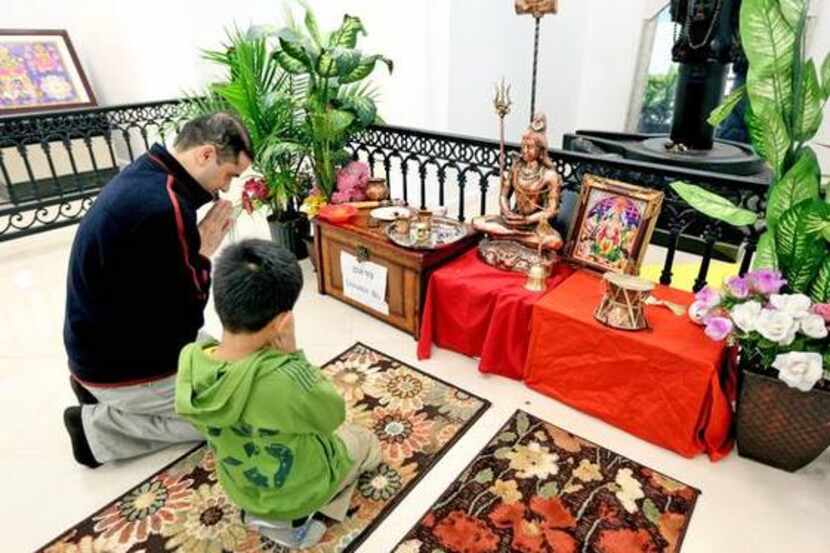 
Deepak R. Pokhrel and his son Arush say prayers in the temple at the Nepali Cultural and...