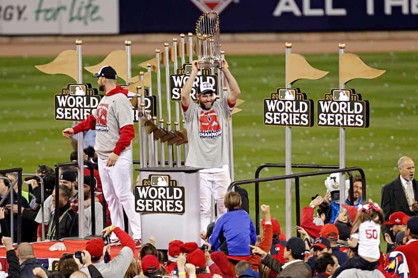 St. Louis Cardinals right fielder Lance Berkman holds the World Series trophy over his head...