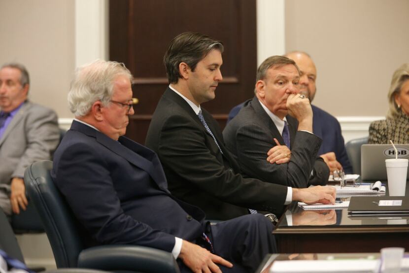 Defense attorneys Andy Savage, left, Don McCune, and Miller Shealy, right, sit around former...