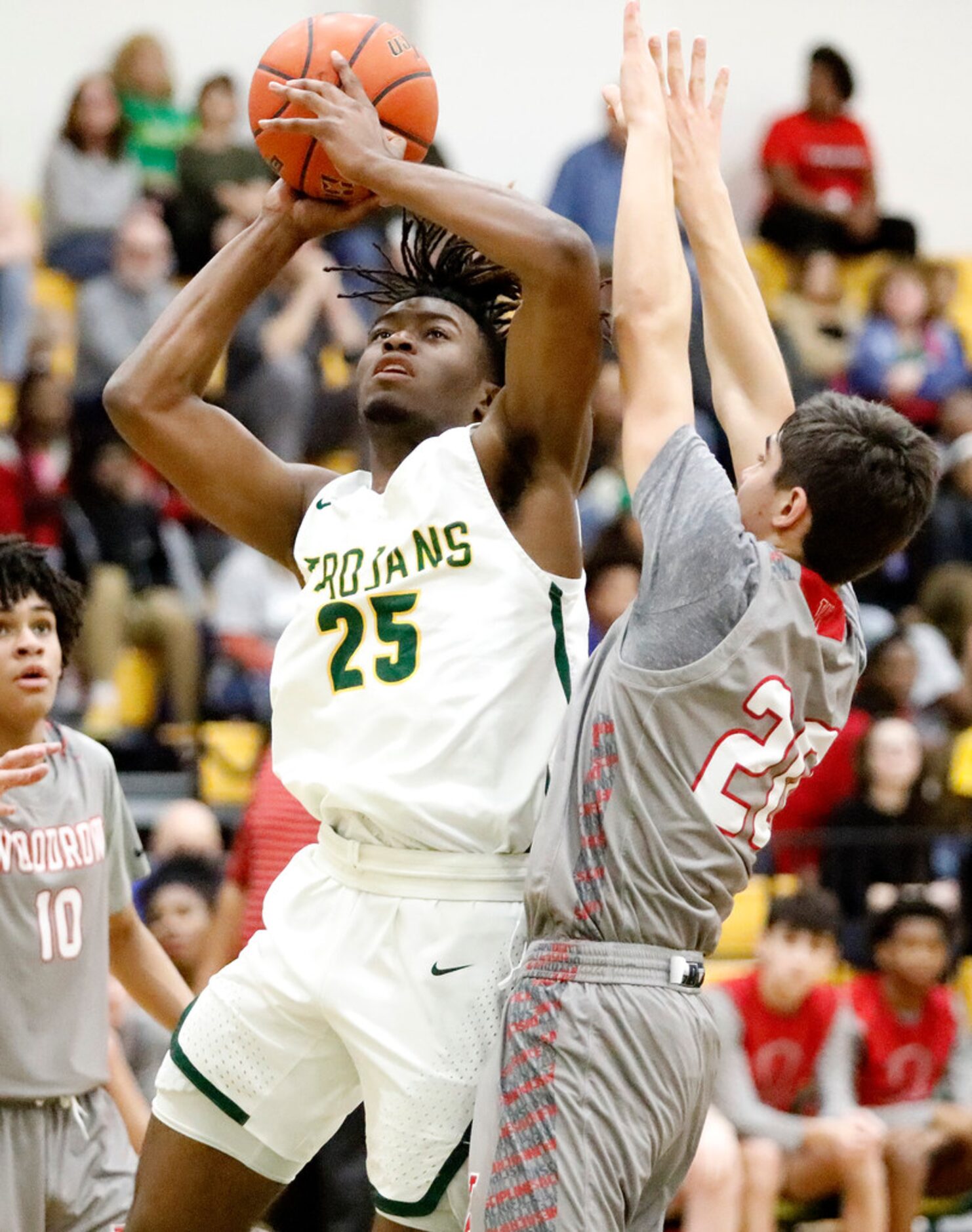 Newman Smith High School forward Domani Villaruel (25) goes up for a shot as Woodrow Wilson...