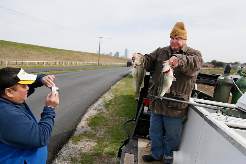 
Than Nguyen (left) of the city of Dallas photographs Bill Wingo with largemouth basses....