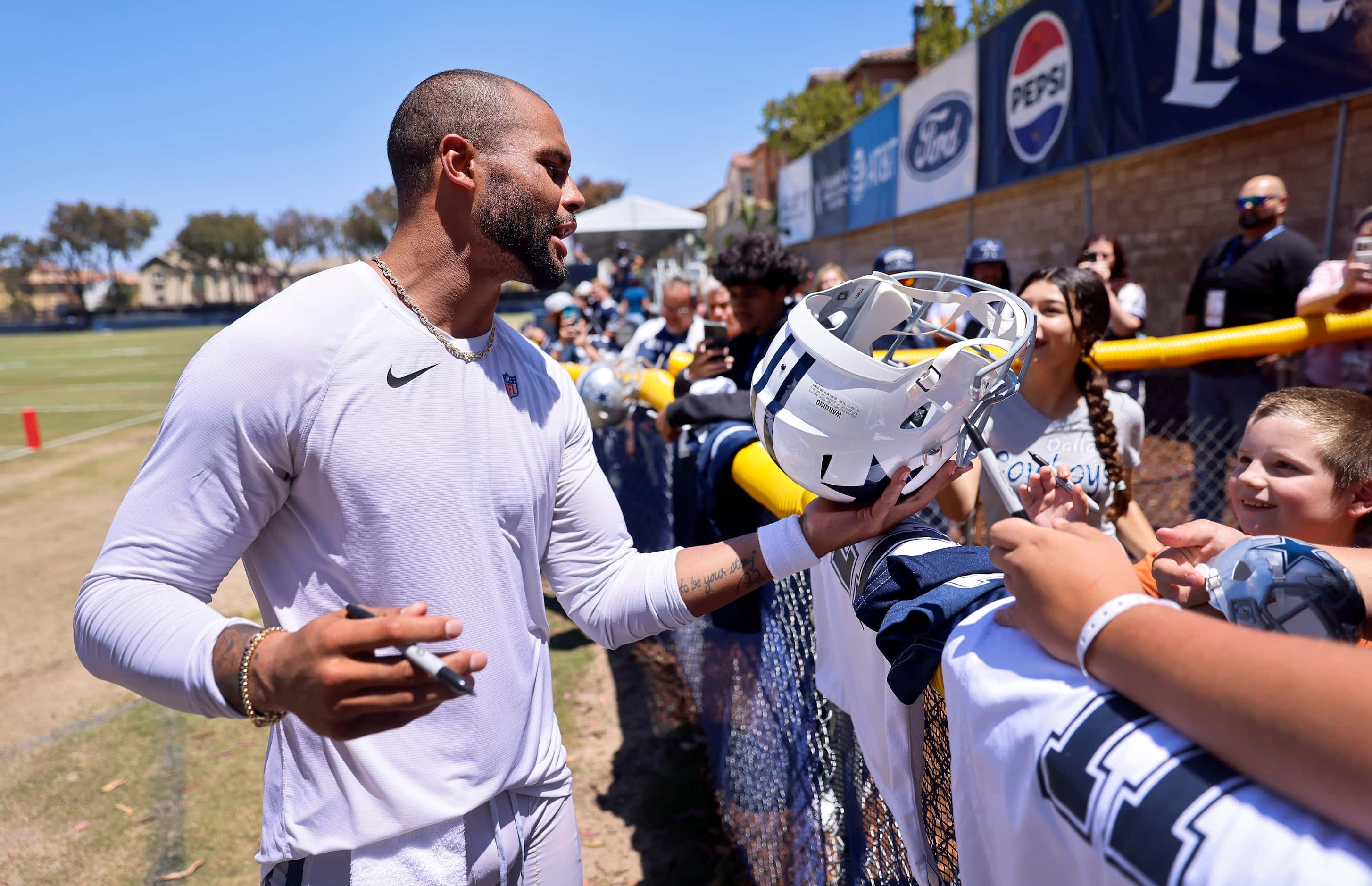 Dallas Cowboys quarterback Dak Prescott signs autographs for fans following training camp...