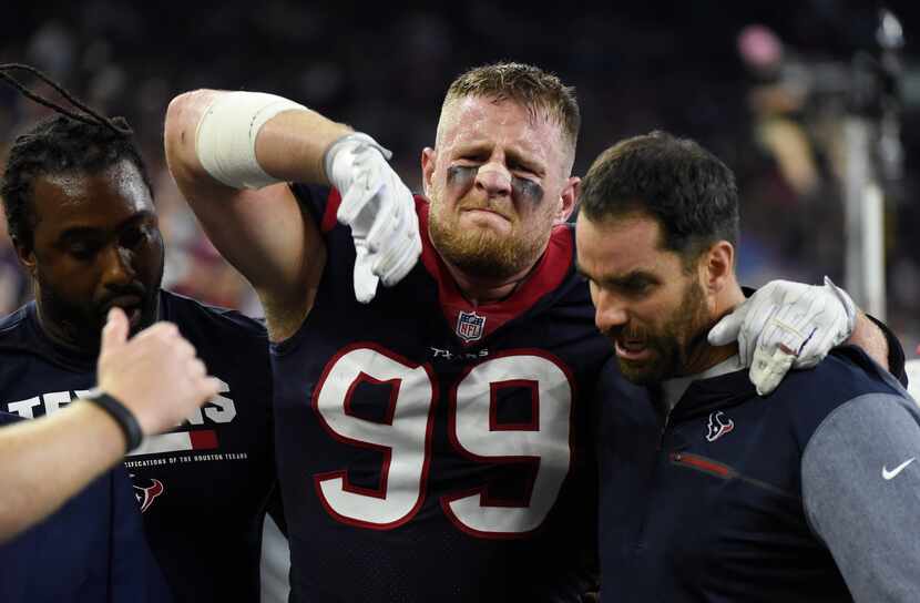 Houston Texans defensive end J.J. Watt (99) is helped off the field after an injury during...