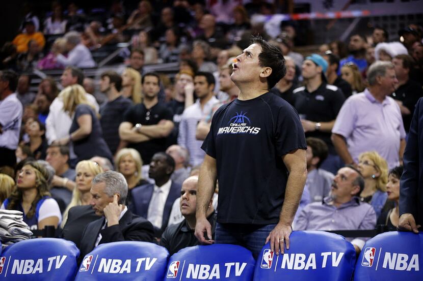 Dallas Mavericks owner Mark Cuban reacts to a video replay as he disagrees with the official...