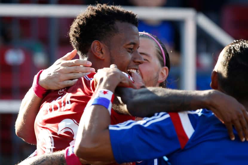 FC Dallas midfielder Kellyn Acosta (23) is hugged by team mates after scoring the insurance...