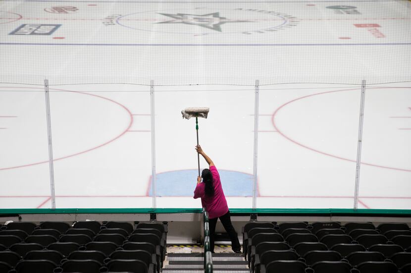 Crews clean and prepare to cover the Dallas Stars ice after the NHL season was put on hold...