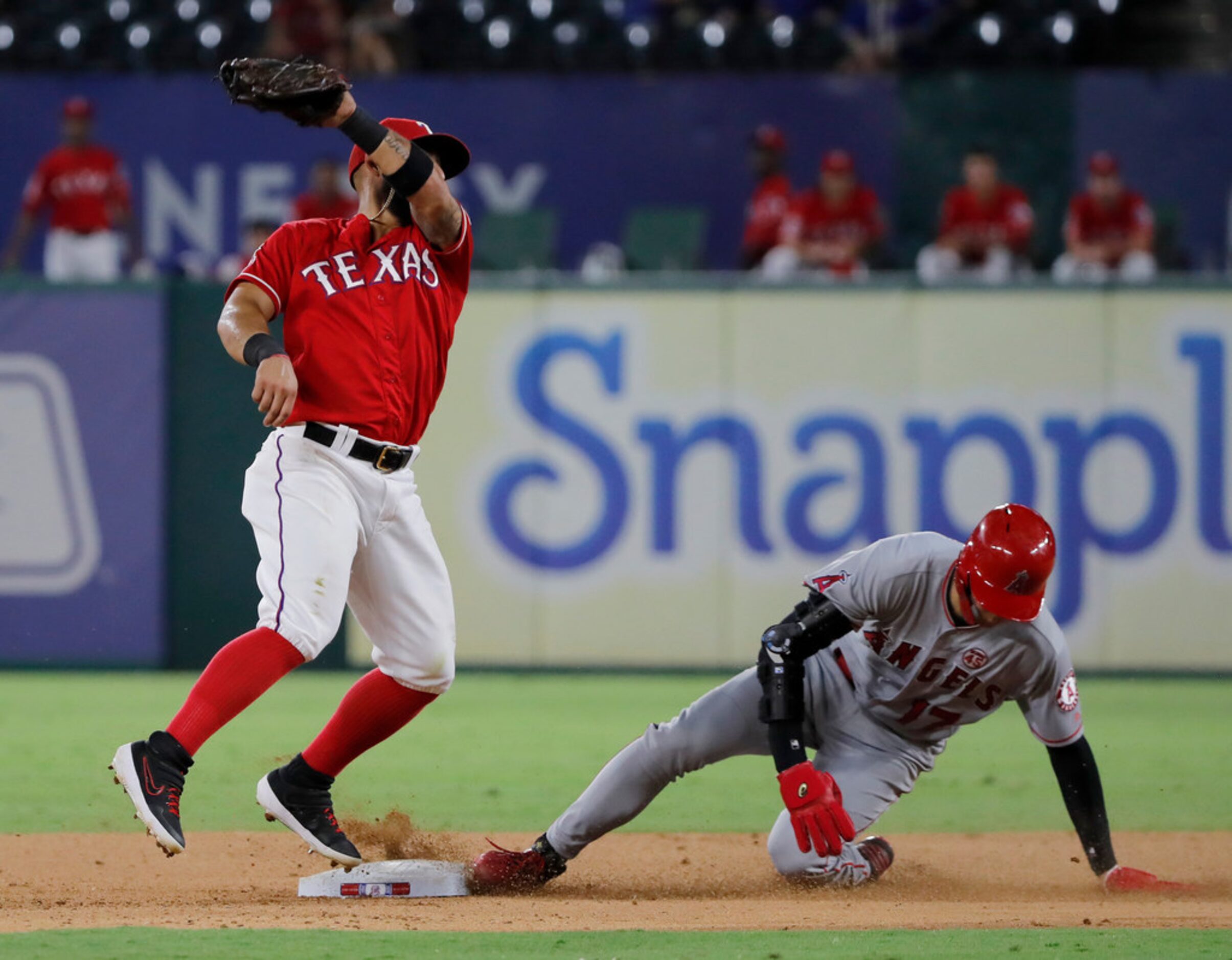 Texas Rangers second baseman Rougned Odor, left, reaches  for the throw to the bag as Los...