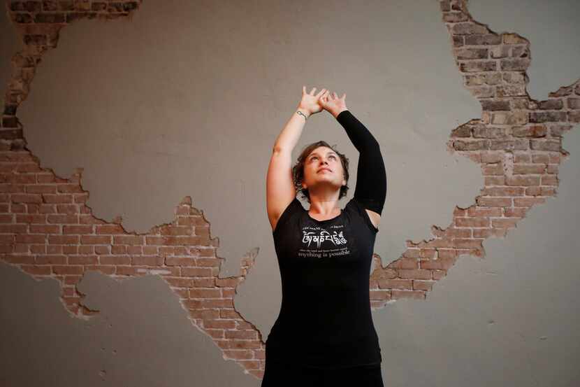 Brandie Sellers stretches prior to teaching a Sunday morning yoga class at Yoga Balance...