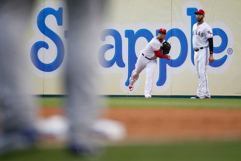 Texas Rangers center fielder Carlos Gomez (14) throws the ball alongside Texas Rangers right...
