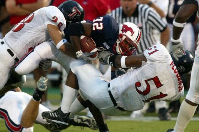 SMU's #32 Keylon Kincade gets tackled by TX Tech's#28 Ryan Aycock and #51 Lawrence Flugence...