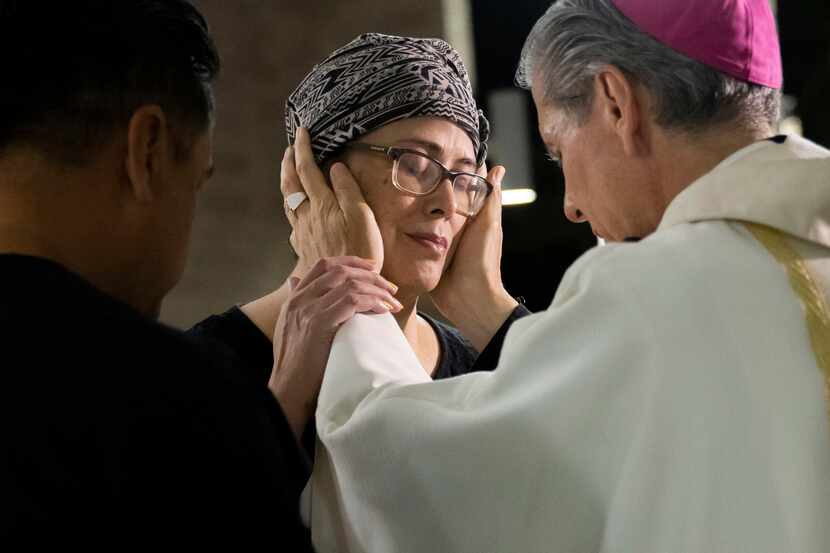Archbishop Gustavo García-Siller prays over Maricela Gonzales and her husband Abraham...