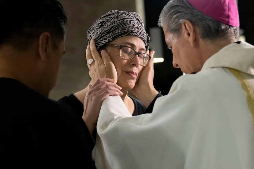 Archbishop Gustavo García-Siller prays over Maricela Gonzales and her husband Abraham...