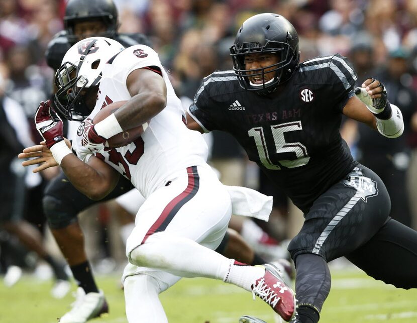 Texas A&M Aggies defensive lineman Myles Garrett (15) tackles South Carolina Gamecocks...