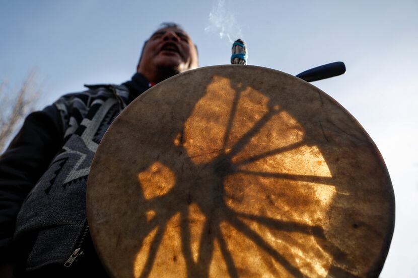 A protestor leads a Native American prayer with a traditional drum outside the Catholic...
