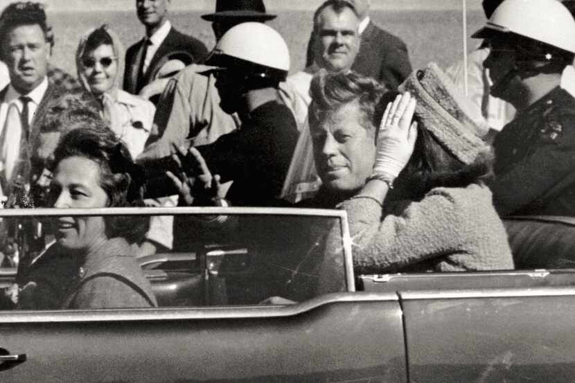 In this Nov. 22, 1963 file photo, President John F. Kennedy waves from his car in a...