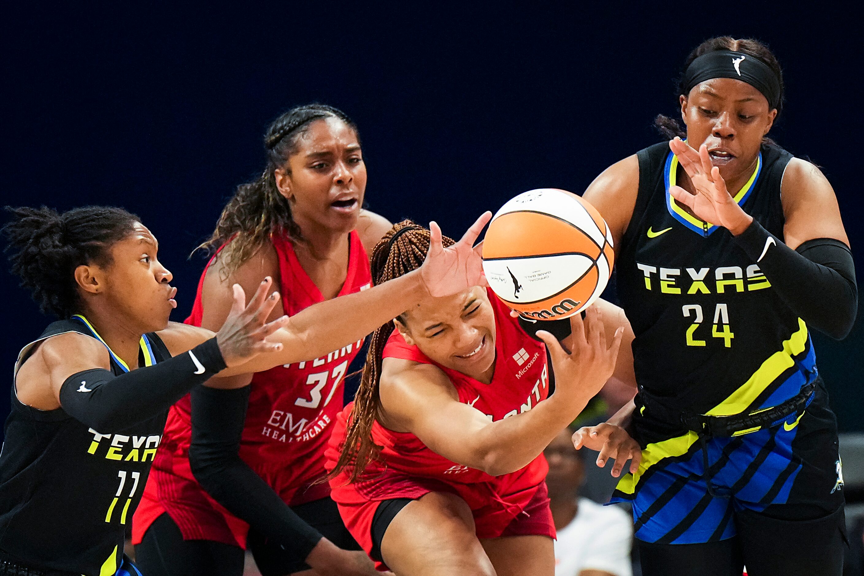 Dallas Wings guard Arike Ogunbowale (24) and guard Crystal Dangerfield (11) fight for a...