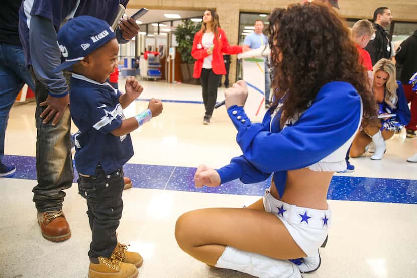 Three-year-old Richard Reed with Dallas Cowboys cheerleader Maddie Massingill during the...