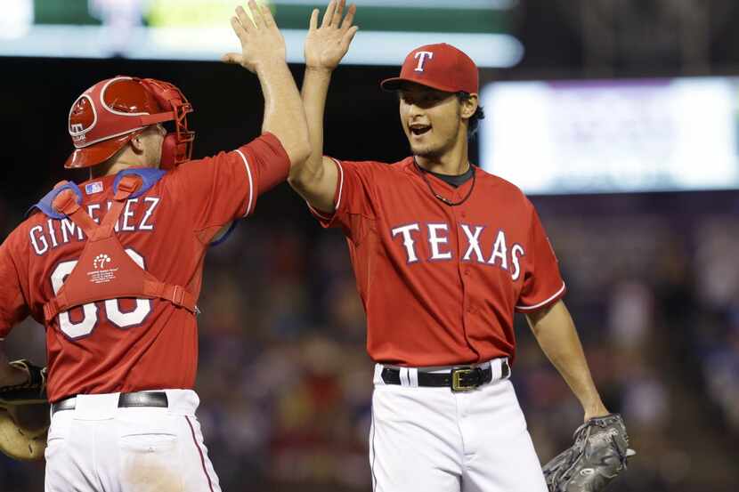Texas Rangers starting pitcher Yu Darvish, right, of Japan, celebrates with catcher Chris...