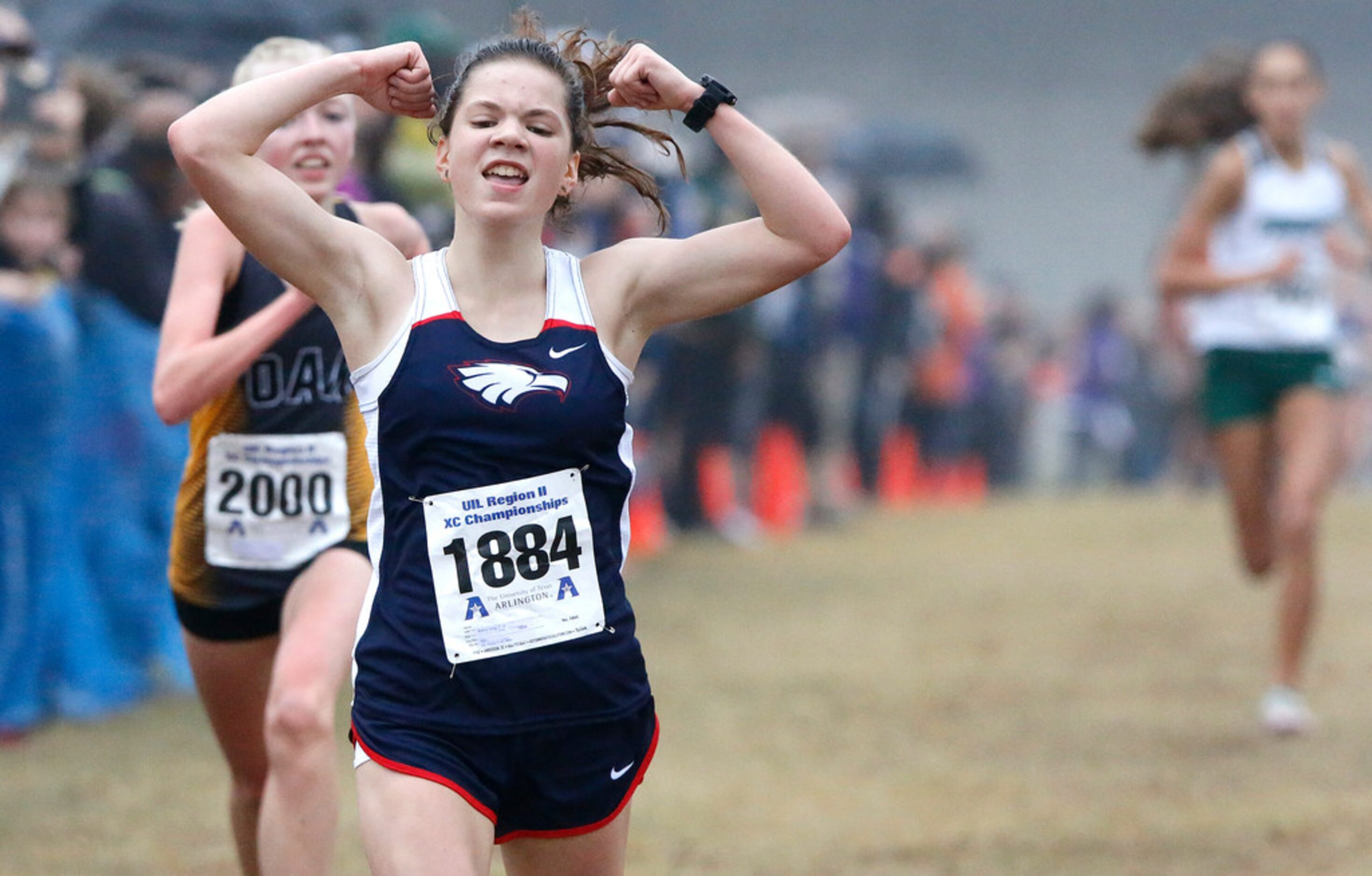 Allen High School's Brenna Zerby (1884) lifts her hands as she finishes second in the girls...