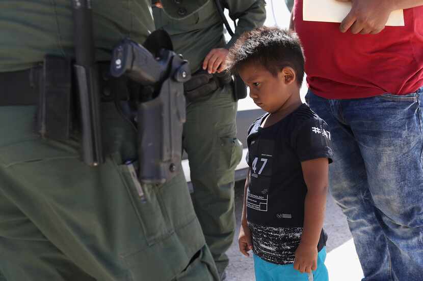 A boy and father from Honduras are taken into custody by U.S. Border Patrol agents near the...