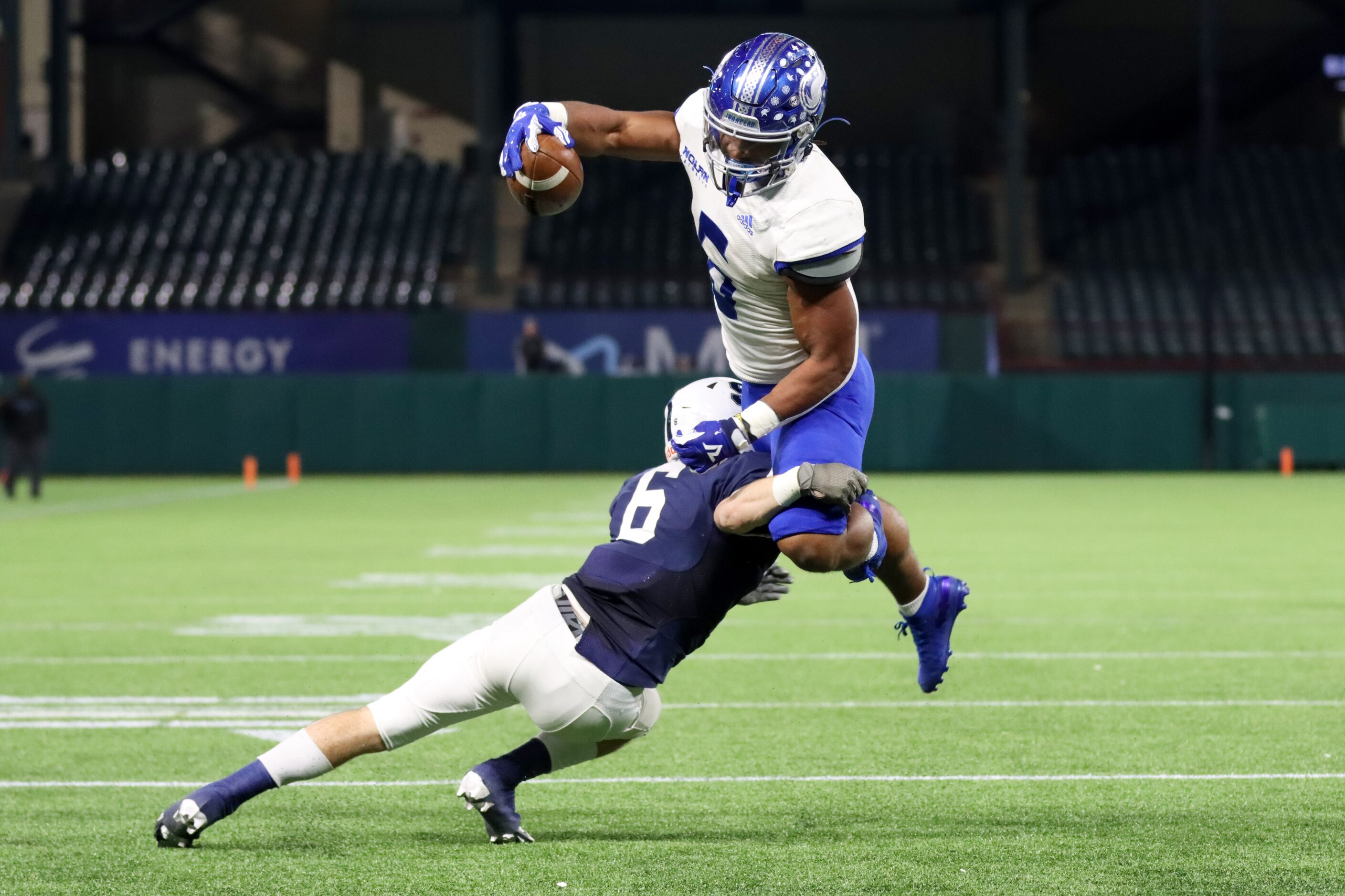 Fort Worth Nolan running back Emeka Megwa (6) leaps over Fort Worth All Saints cornerback...