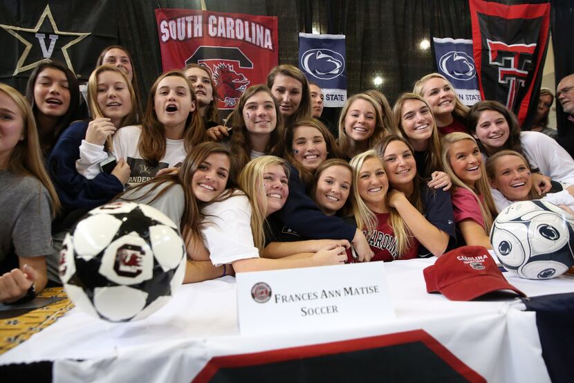 The Highland Park girls soccer team poses for a photograph with the four signees during...