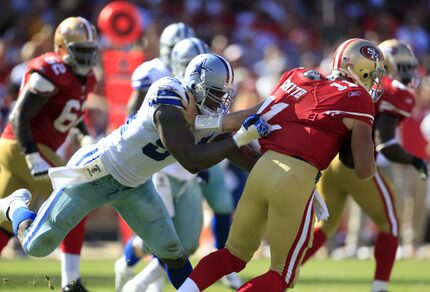 DeMarcus Ware (94) derriba al mariscal de campo de los 49'ers de San Francisco, Alex Smith,...