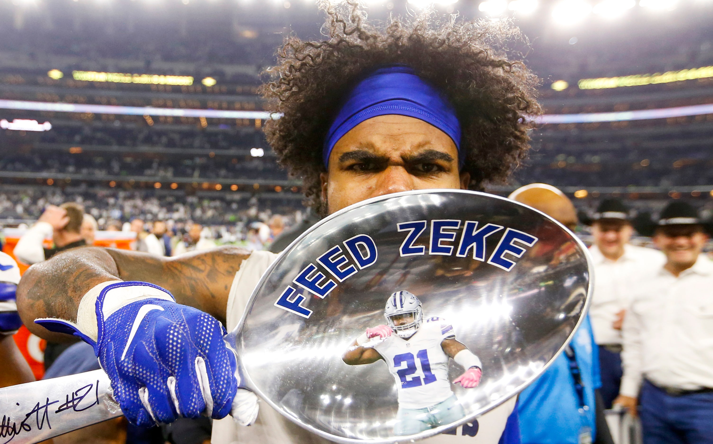 Dallas Cowboys running back Ezekiel Elliott (21) gestures his feed me after signing a giant...