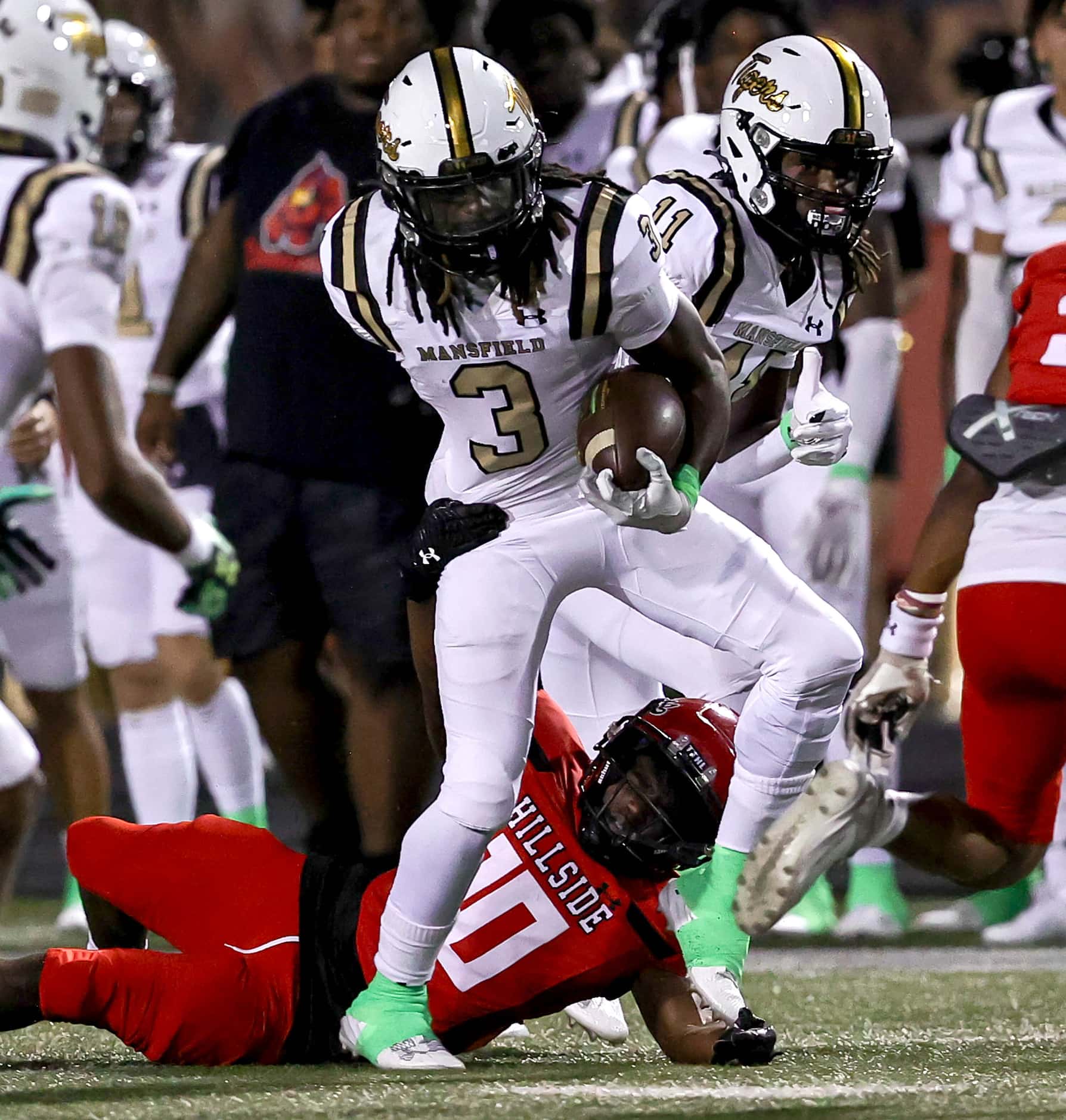 Mansfield running back James Johnson (3) tries to break a tackle from Cedar Hill linebacker...