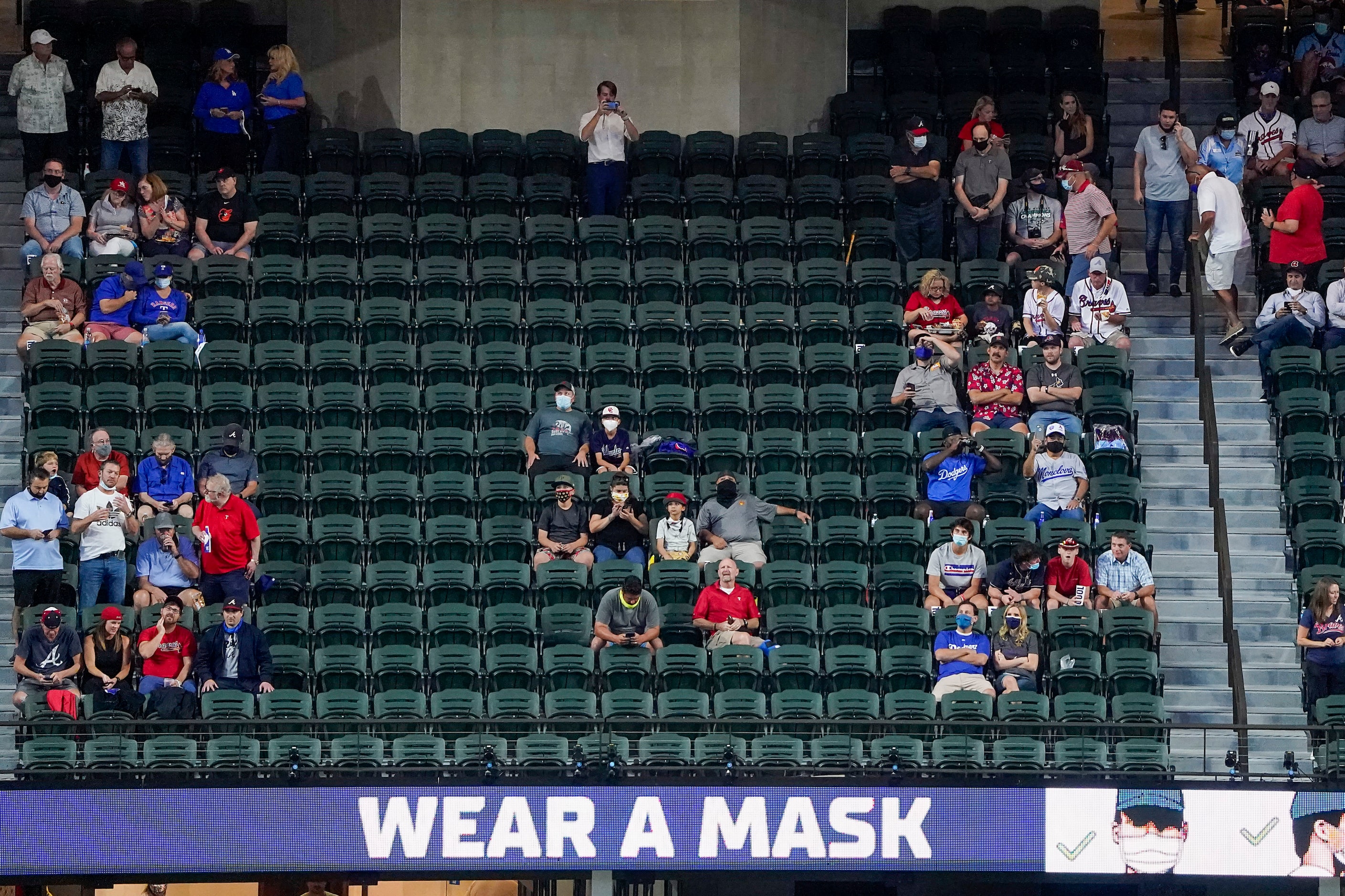 Signs encourage mask wearing during first inning in Game 1 of a National League Championship...