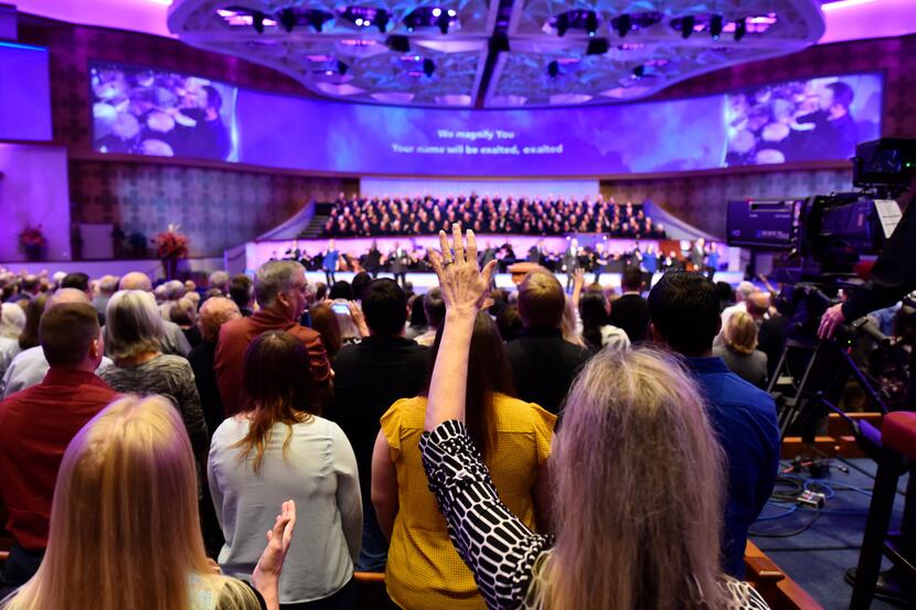 Parishioners raise their hands during a worship song at First Baptist Dallas on Oct. 22,...