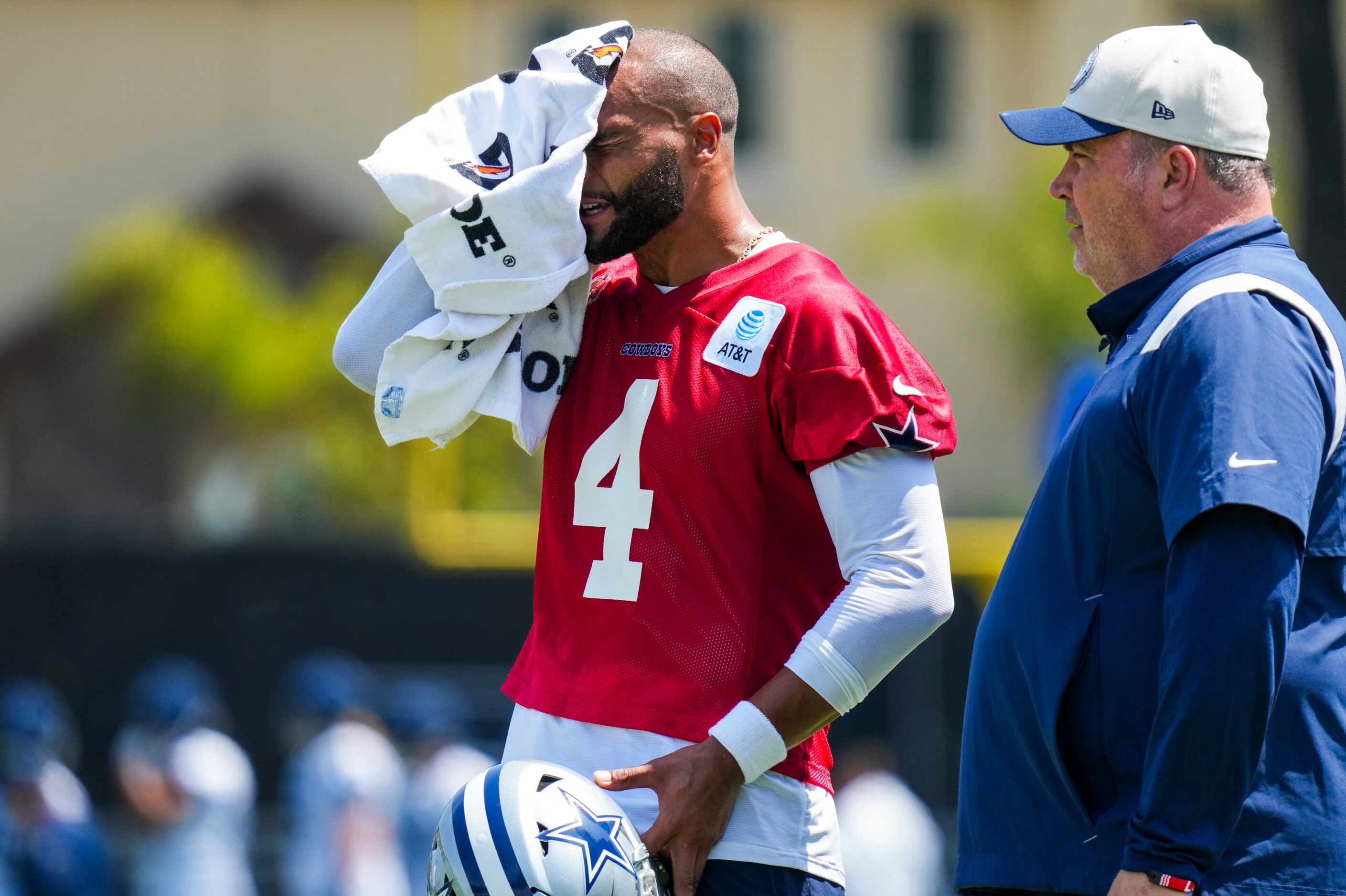 Dallas Cowboys quarterback Dak Prescott (4) towels off as he talks with Dallas Cowboys head...