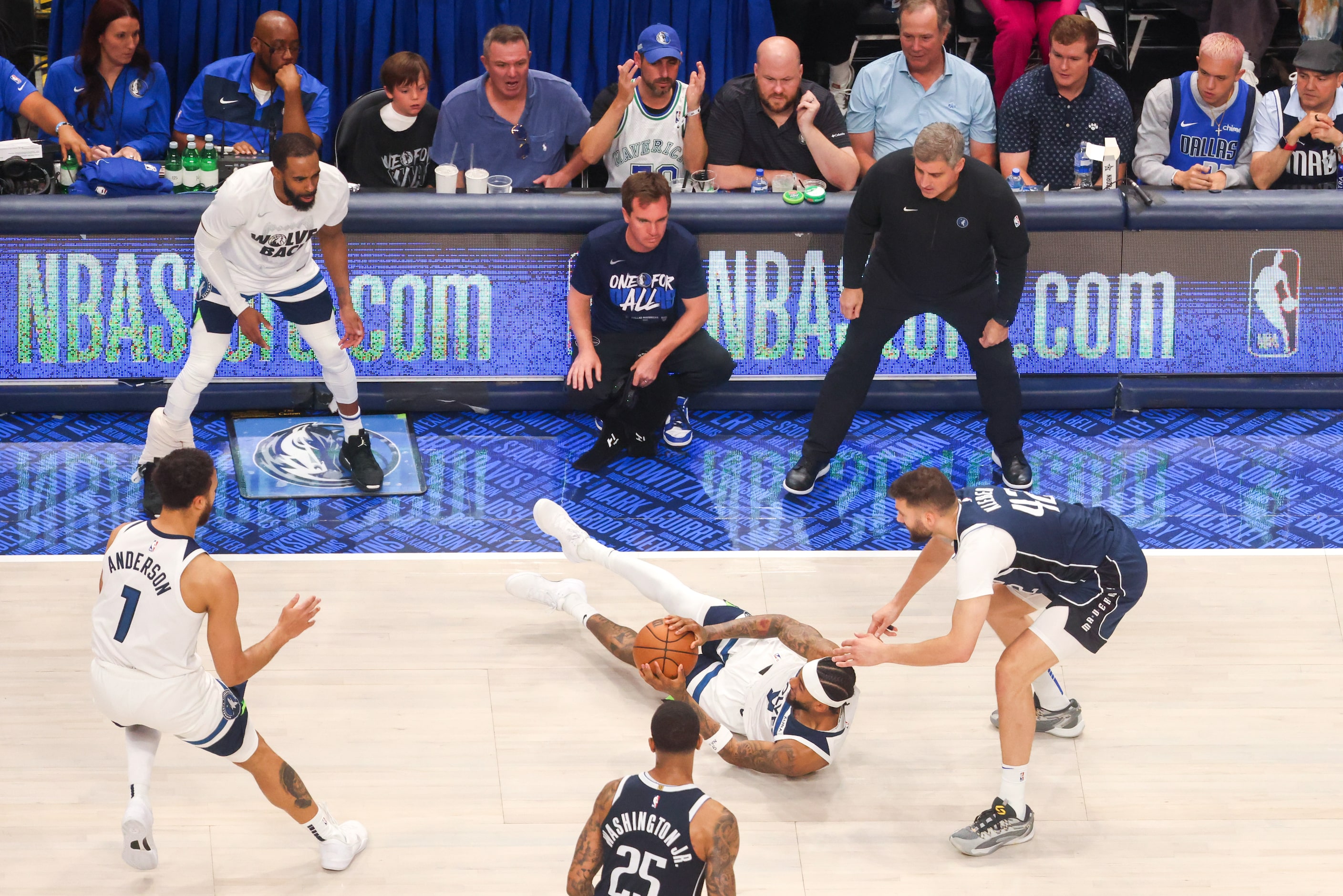 Minnesota Timberwolves forward Jaden McDaniels (center) recovers a loose ball against Dallas...