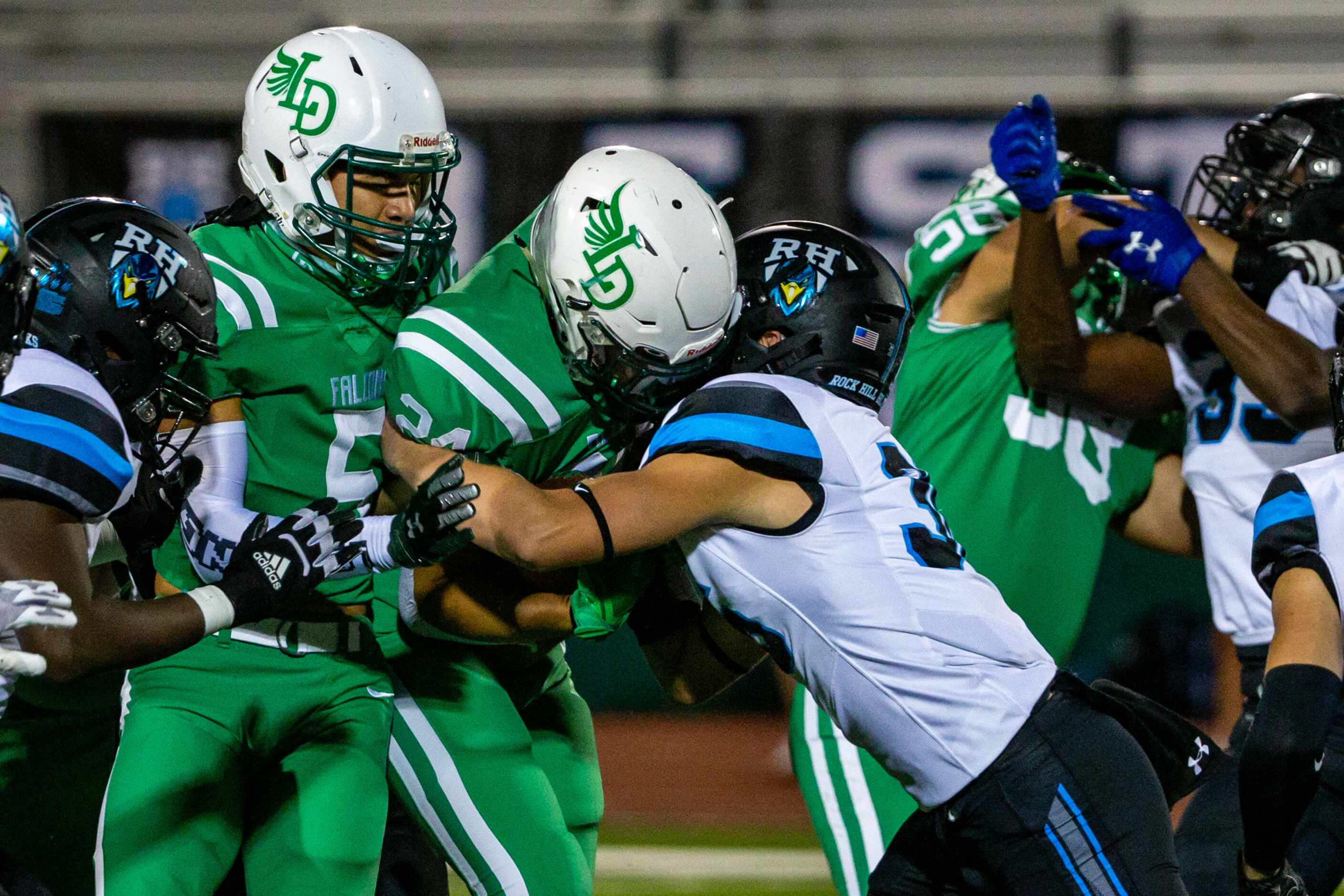 Rock Hill defensive back Gage Humbarger (36, right) blocks a run by Lake Dallas running back...