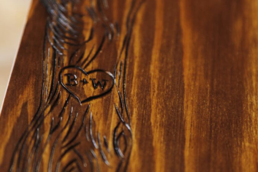 Her detailed designs are burned into the wood.