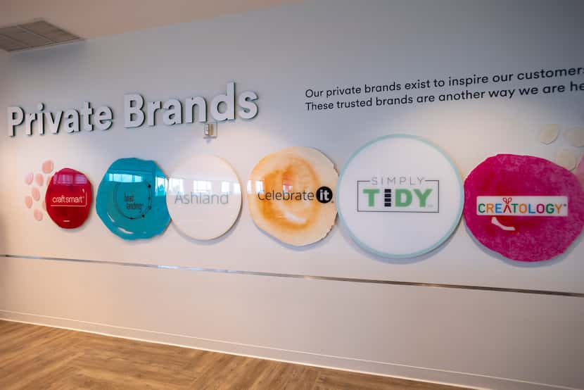 Logos from some of the private brands owned by Michaels are on display at the company's new...
