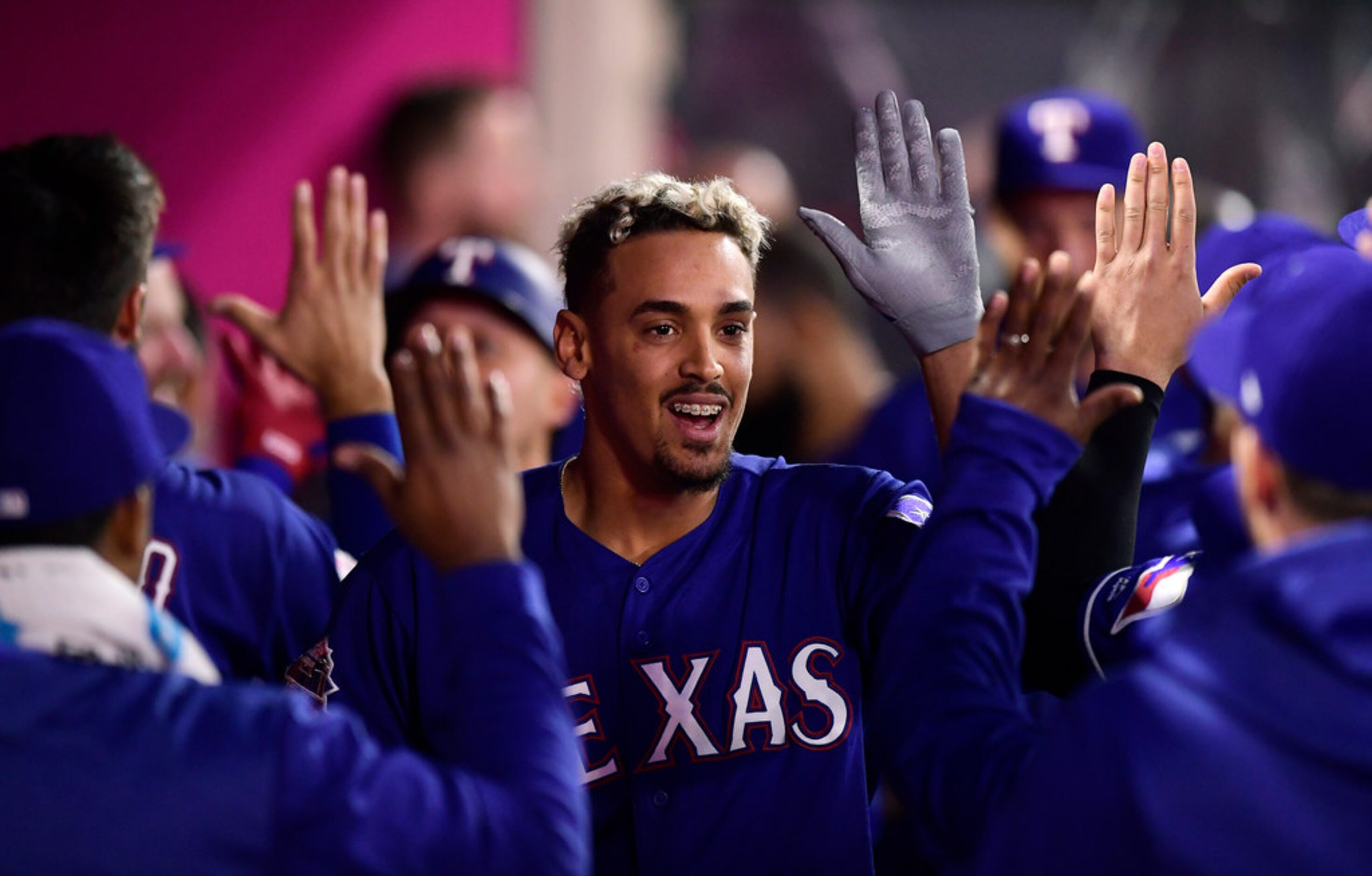 Texas Rangers' Ronald Guzman is congratulated by teammates after hitting a two-run home run...