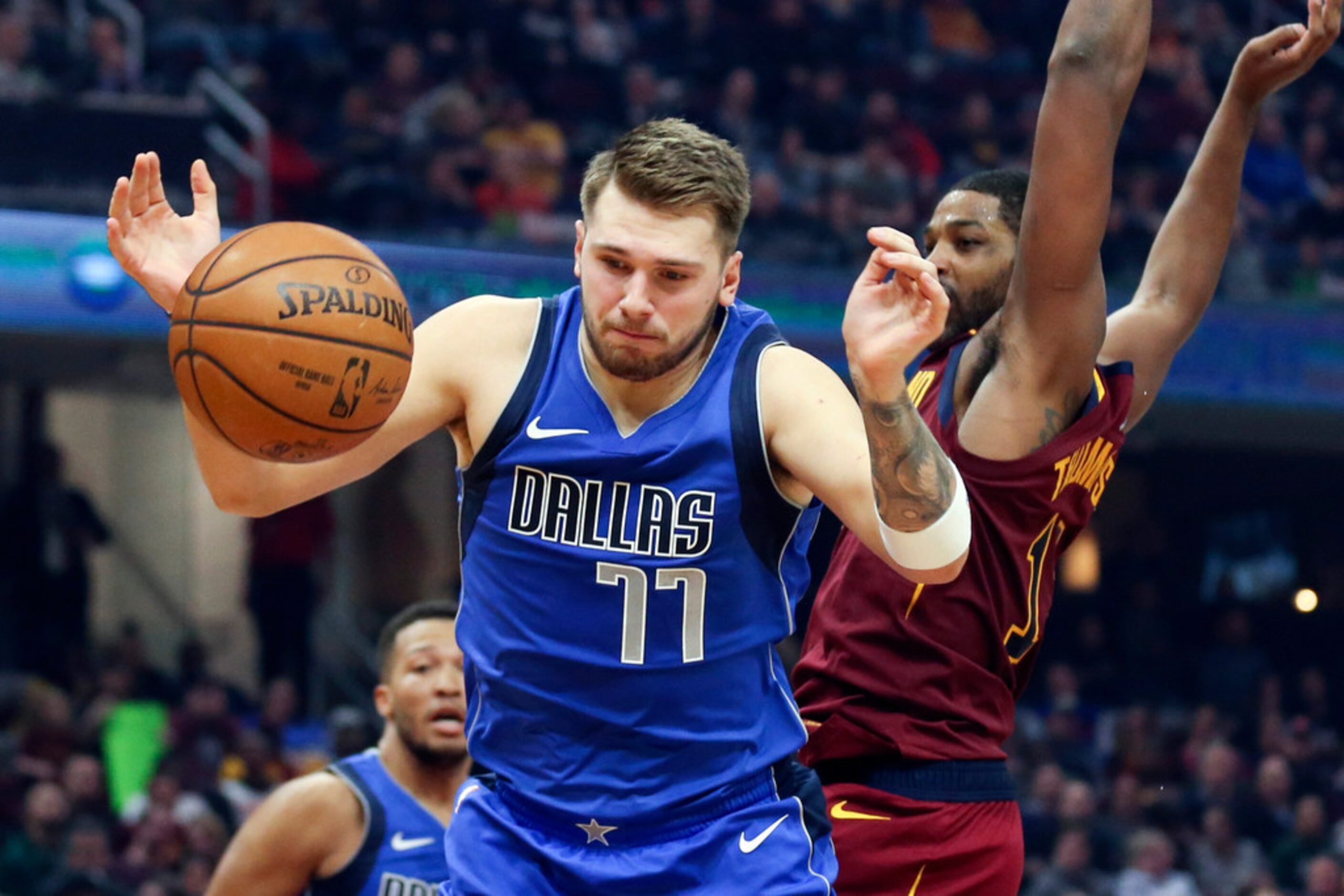 Dallas Mavericks' Luka Doncic (77) battles Cleveland Cavaliers' Tristan Thompson for a...