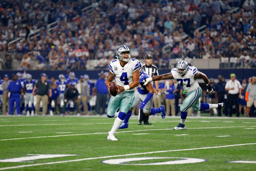 Dallas Cowboys quarterback Dak Prescott (4) scrambles out of the pocket before throwing a...
