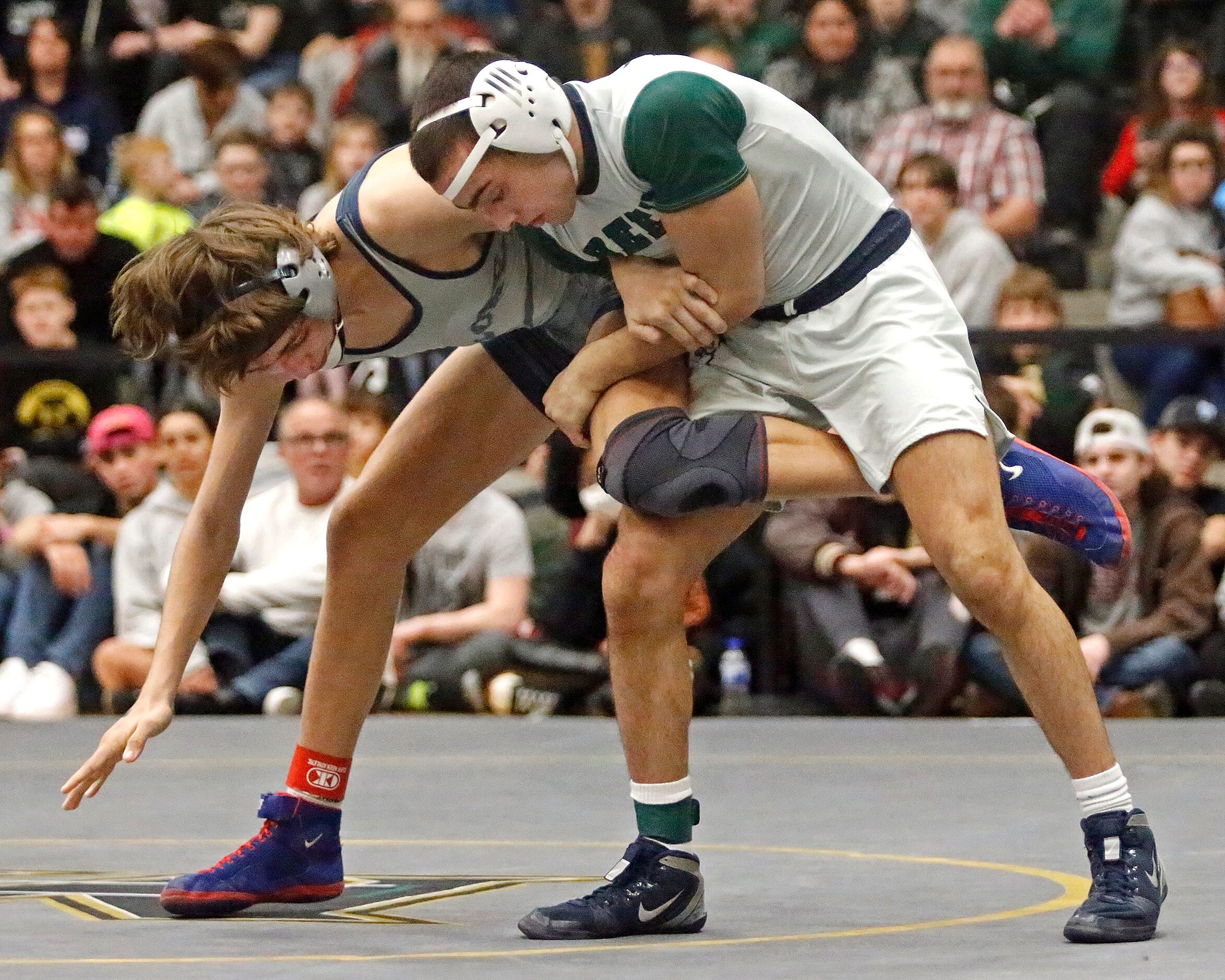 Max Villasana (right) of Reedy High School holds the leg of Janick Schwab of Frisco Lone...