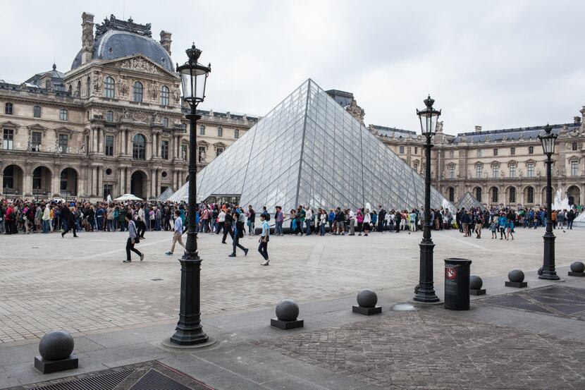 The waiting line for entrance to the Louvre Museum, next to the glass pyramid designed by...