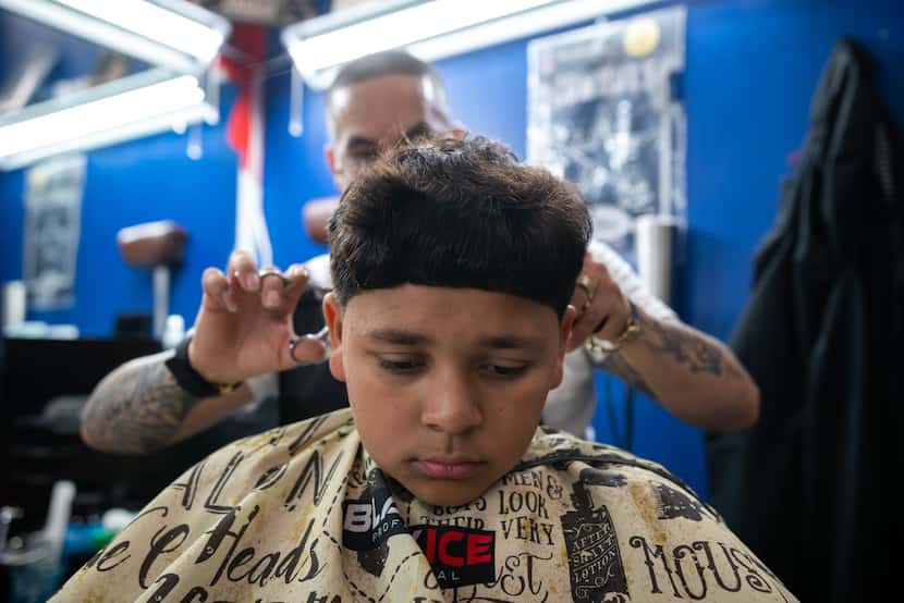 Barber Edgar "E" Montelongo gives Nathan Cabrera an Edgar cut at Old East Dallas Barbershop....