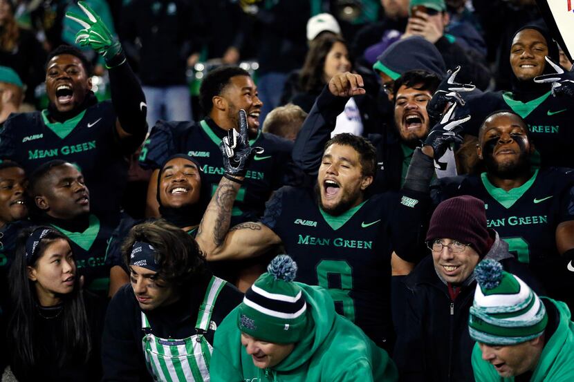 North Texas Mean Green football players celebrate their win in the student section of Apogee...