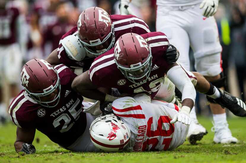Texas A&M Aggies defenders tackle Ole Miss running back Isaiah Woullard (26) during the...
