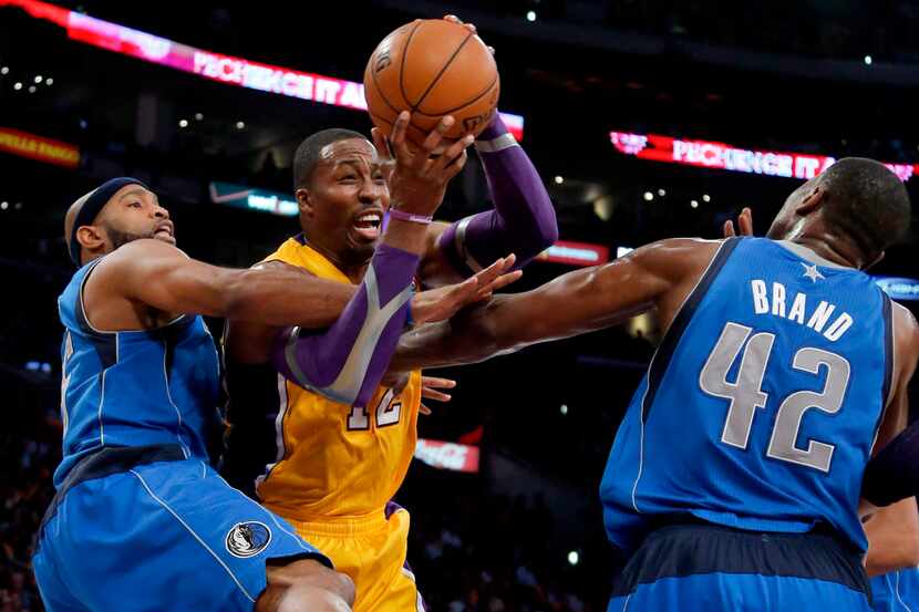 Los Angeles Lakers' Dwight Howard, center, is defended by Dallas Mavericks' Vince Carter,...