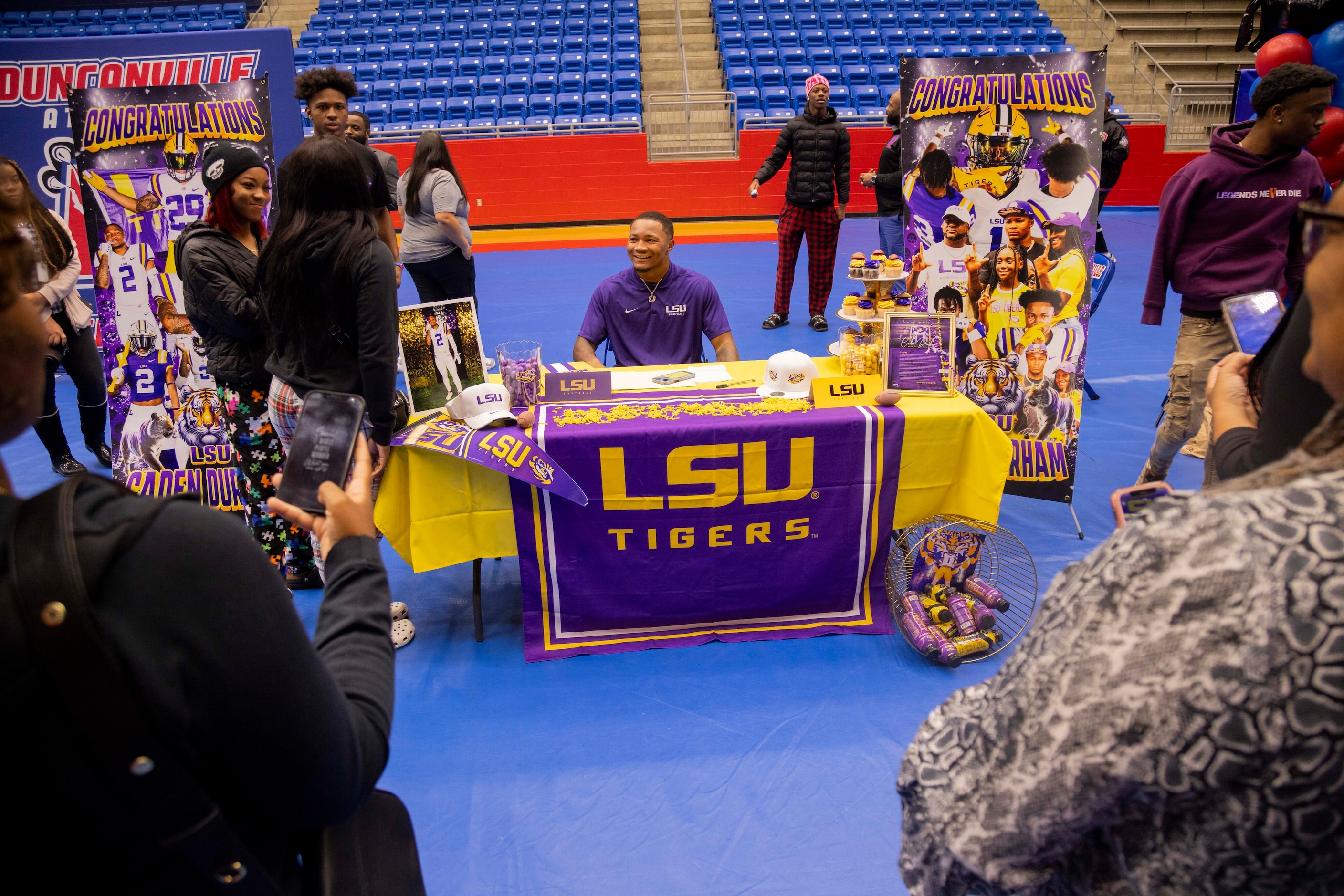 Running back Caden Durham smiles as family and friends gather around him after signing his...