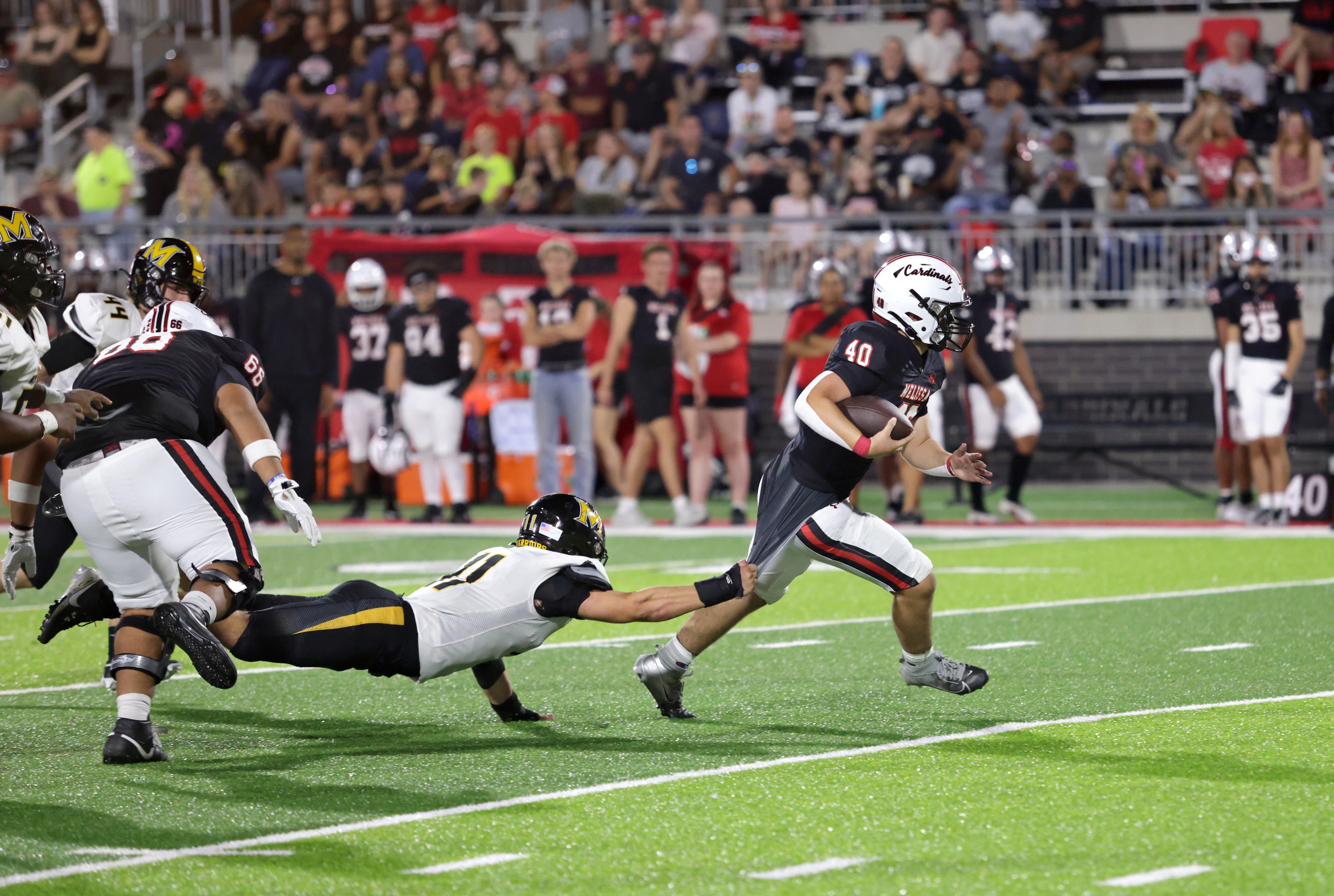 Memorial player #11 Austin Metcalf attempts to take down Melissa player #40 Billy Heid...